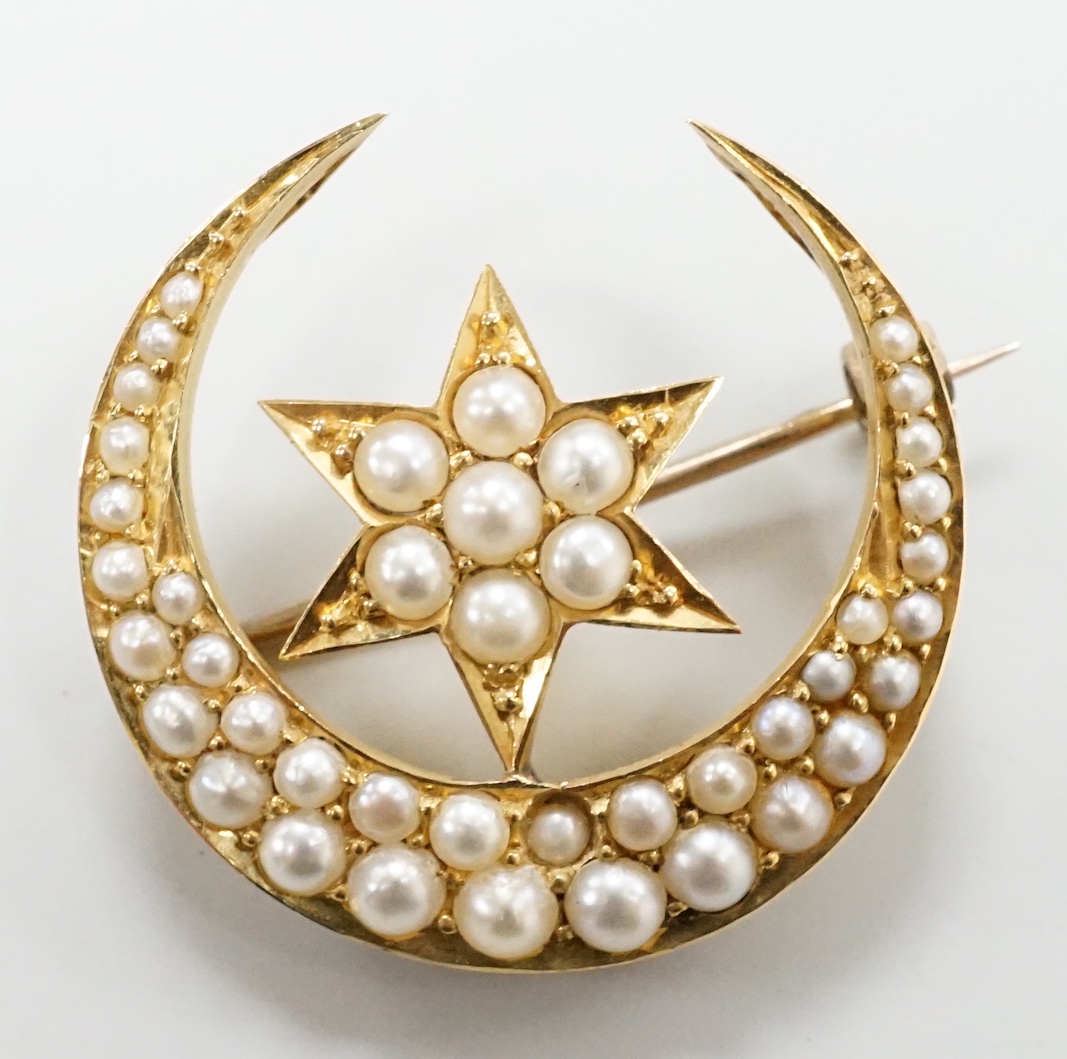 An Edwardian yellow metal and seed pearl set 'star and crescent moon' brooch, 26mm, 6.1 grams, in fitted case.